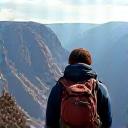 A single backpacker looking over a vast canyon.